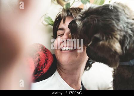 Glückliches Mädchen macht Selfie mit Hund Spaß und leckt ihr Gesicht - Liebe und Haustier Freundschaft Stockfoto