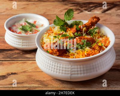 Traditionelles Hyderabadi Chicken dum Biryani aus Basmati-Reis, zubereitet mit Masala-Gewürzen, serviert mit Zwiebelraita, selektiver Konzentration Stockfoto