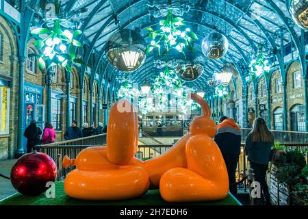 London, Großbritannien. 22nd. November 2021. Fröhlicher Ballonhund von Castle Fine Art, der Geld an die Tierschutzorganisation Blue Cross gibt - Menschenmassen durchstöbern die Geschäfte und beobachten Straßenunterhalter unter dem weihnachtsbaum, riesige Misteln und andere Lichter in einem belebten Covent Garden, wenn der Weihnachtsanlauf beginnt. Kredit: Guy Bell/Alamy Live Nachrichten Stockfoto