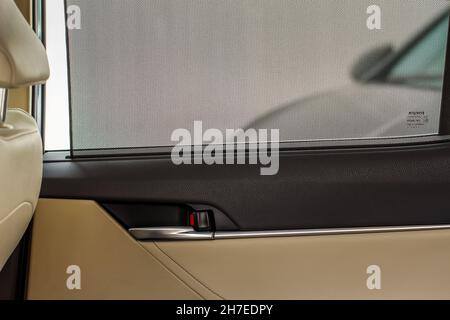 Offener Sonnenschutz. Fenstervorhänge an der Fahrzeugseite, Sonnenschirme. Sonnenschutzvorhang in einem modernen Auto. Stockfoto