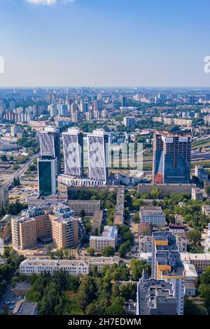 Luftaufnahmen, städtische Wohngebiete und grüne Parks im Sommer blauen Dunst und Sonnenlicht. Vertikales Bild. Stockfoto