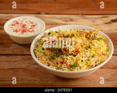 Traditionelles Hyderabadi Chicken dum Biryani aus Basmati-Reis, zubereitet mit Masala-Gewürzen, serviert mit Joghurt, selektiver Fokus Stockfoto