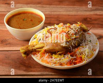 Traditionelles Hyderabadi Chicken dum Biryani aus Basmati-Reis, zubereitet mit Masala-Gewürzen, serviert mit Salan, selektiver Fokus Stockfoto