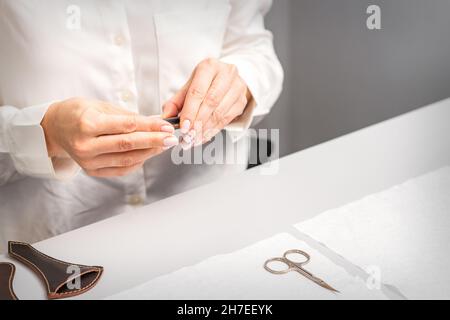 Professioneller Manikurist, der Werkzeuge für die Nagelpflege der Kunden vorbereitet Stockfoto