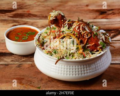 Traditionelles Hyderabadi Chicken dum Biryani aus Basmati-Reis, zubereitet mit Masala-Gewürzen, serviert mit Salan, selektiver Fokus Stockfoto