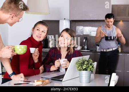 Junge Reisende mit Laptop planen touristische Reiseroute während des Frühstücks Stockfoto