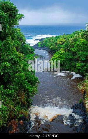 Palikea Stream läuft durch vulkanisches Gestein in den Ozean, Haleakala National Park, Maui, Hawaii Stockfoto