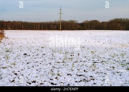 Schnee auf einem gepflügten Feld. Frühling und schmelzender Schnee. Früher Frühling auf den Feldern. Stockfoto