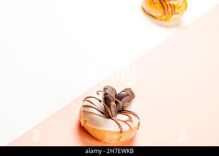 Foto von 1 weißen Donuts mit Schokoladenkeksen und einer Seite von unfokussierten Cremedonuts.das Foto ist im horizontalen Format aufgenommen und hat ein zwei-Ko Stockfoto