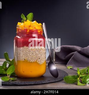 Gesundes Frühstück Chia Samen Pudding mit Mango und Erdbeeren Püree Stockfoto