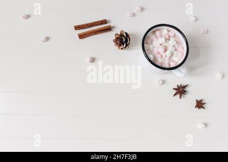 Komposition im Weihnachtsstil. Heiße Schokolade, Moorsalbe, Zimtstangen, Anissterne. Tannenzapfen auf weißem Holztisch Hintergrund. Festlicher Winter Stockfoto