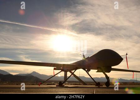 Indian Springs, Vereinigte Staaten von Amerika. 08. Dezember 2016. Ein unbemanntes Luftfahrzeug der US Air Force MQ-1 Predator wird durch die untergehende Sonne am Boden auf dem Creech Air Force Base am 8. Dezember 2016 in der Nähe von Las Vegas, Nevada, silhouettiert. Quelle: SRA Christian Clausen/US Air Force Photo/Alamy Live News Stockfoto