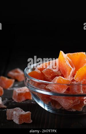 Natürliche Farm hausgemachte kandierte Kürbisfrüchte bestreut mit Puderzucker in einer Glasschüssel auf einem Holztisch Stockfoto