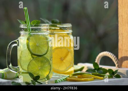 Kalte, erfrischende hausgemachte Limonade mit Minze, Zitrone und Limette in Maurergläsern. Stockfoto