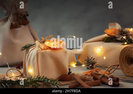 Null Abfall weihnachtskonzept. Verpackt in Naturstoff Geschenke und Dekorationen aus natürlichen Materialien mit weihnachtsbeleuchtung. Stockfoto