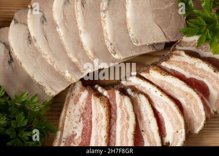 Aufschnitt von Schweinefleisch auf einer Holzplatte Stockfoto