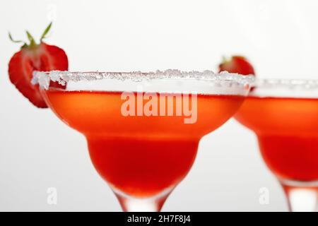 Frisch erfrischender Erdbeer-margarita-Cocktail in Gläsern auf weißem Hintergrund. Stockfoto