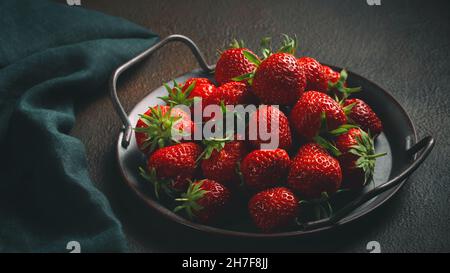 Reife frisch gezüchte natürliche Erdbeeren auf einem Metalltablett auf dem Tisch. Stockfoto