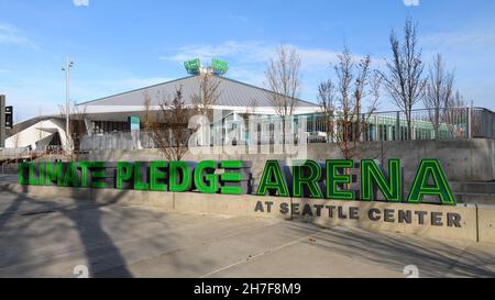 Seattle - 21. November 2021; Schatten von Bäumen überqueren den Bürgersteig und berühren das Schild für die Climate Pledge Arena in Seattle unter blauem Himmel Stockfoto
