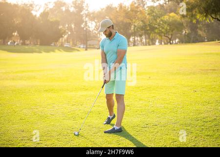 Schöner Mann spielt Golf-Spiel auf grünem Gras, Erholung Stockfoto
