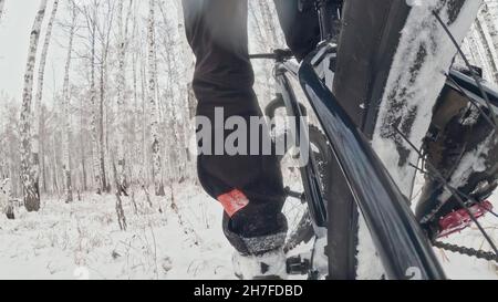 Action Cam am dahinter installierten Rahmen. Nahaufnahme der Pov-Ansicht. Professioneller Extremsportler Biker, der im Winterschneehaus im Freien fette Bikes fährt. Stockfoto