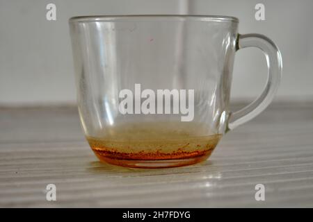 Eine Tasse aus Glasmaterial und Remanings des Tees und es steht auf Edelstahl Küchenspüle Stockfoto