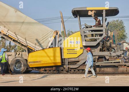 Phayao, Thailand - 27. Jan 2021: Asphaltfertiger und LKW und Arbeiter arbeiten auf der Straße Stockfoto