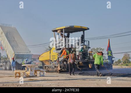 Phayao, Thailand - 27. Jan 2021: Back of Worker und Asphalt Paver and Truck auf der Asphalth Road Stockfoto