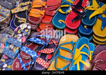 Bunte handgemachte Chappalls (Sandalen), die auf einem indischen Markt verkauft werden, handgefertigte Lederschuhe, traditionelle Schuhe. Stockfoto