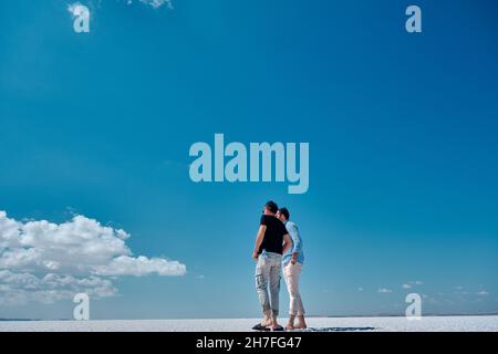 Horizont in salina und Salzsee (tuz golu) und Männer schauen zum Horizont, der blauen Himmel und weiße Seenoberfläche trennt. 23.07.2021. Tuz Golu . Türkei Stockfoto