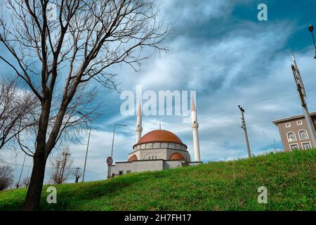 Zwei Minarette und eine neu errichtete Moschee mit ihrer roten Kuppel Stockfoto