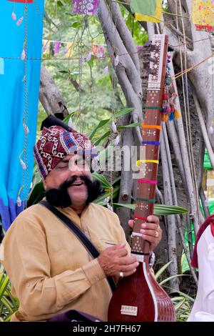 Pune, Maharashtra / Indien - 18. November 2021: Rajasthani Folk-Sänger mit Turban und Schnurrbart mit einem Musikinstrument beim Local Festival Event. Stockfoto