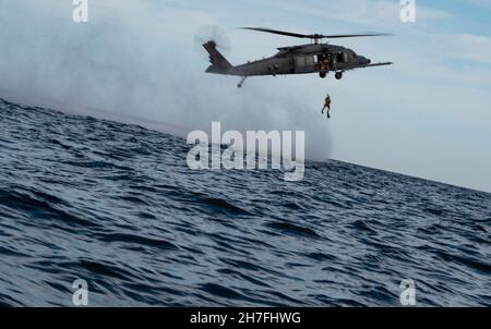 Ein Mitarbeiter der US-Luftwaffe, der dem Rettungsgeschwader von 38th zugewiesen wurde, schiebt von einem HH-60W Jolly Green II ab, um während des Mosaic Tiger 22-1 südlich von Alligator Point, Florida, am 18. November 2021 ein isoliertes Personal wiederzuerlangen. Mosaic Tiger 22-1 ist eine Command and Control-Übung, die die Fähigkeiten des 23rd Wings im Lead-Wing schärfen soll. (USA Foto der Luftwaffe von Staff Sgt. Jordan Garner) Stockfoto