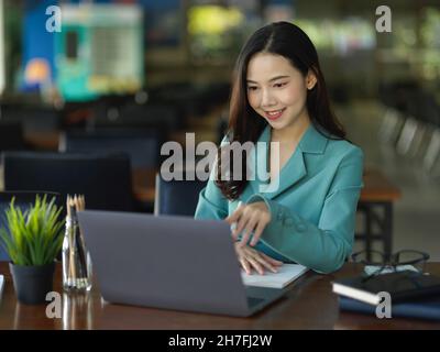 Professionelle und elegante Geschäftsfrau arbeitet auf einem Laptop-Computer im modernen Büroarbeitsbereich. Stockfoto