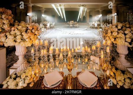 Hochzeitssaal mit Hochzeitsbühne, dekoriert mit frischen Blumen und Kerzen Stockfoto