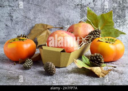 Stillleben von saisonalen Früchten, Blättern und Zapfen im grunge Hintergrund Stockfoto