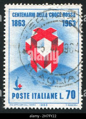 ITALIEN - UM 1963: Briefmarke gedruckt von Italien, zeigt Kreuze und hundertjähriges Emblem auf Globe, um 1963 Stockfoto