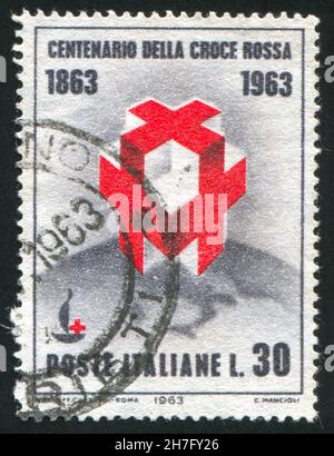 ITALIEN - UM 1963: Briefmarke gedruckt von Italien, zeigt Kreuze und hundertjähriges Emblem auf Globe, um 1963 Stockfoto