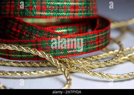 Makro abstrakte Textur Hintergrund von roten und grünen Weihnachten karierte Band und Gold Farbe gedrehten Seil Band mit Kopierer Raum Stockfoto