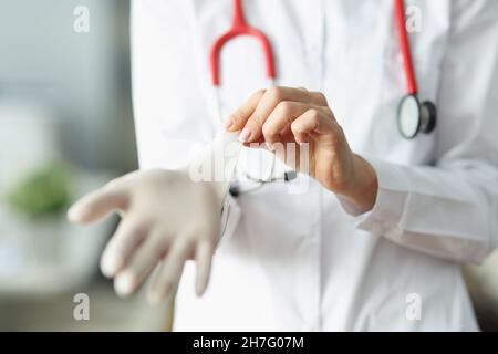 Arzt oder Krankenschwester, die vor der Arbeit in der Klinik sterile Handschuhe anziehen Stockfoto