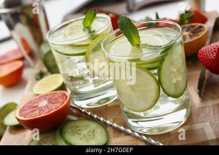 Ein paar leckere erfrischende Cocktails mit Zitronen- und Gurkenscheiben, die mit Minze verziert sind Stockfoto