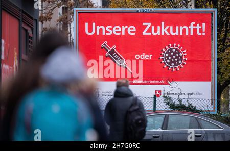 Hannover, Deutschland. 23rd. November 2021. Eine Plakatkampagne der Niedersächsischen Landesregierung mit Inschrift und Symbolen "Unsere Zukunft! Impfungen oder Infektionen/Viren“ fördert die Impfung gegen das Corona-Virus im Stadtzentrum. Die landesweite siebentägige Inzidenz für Infektionen mit dem Corona-Virus ist erneut auf ein Allzeithoch angestiegen. Quelle: Julian Stratenschulte/dpa/Alamy Live News Stockfoto