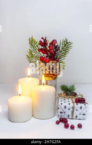 Weihnachtskerzen mit Geschenkbox und Kiefernzweig auf weißem Hintergrund. Neujahrskarte. Weihnachtskollektion Nahaufnahme Stockfoto