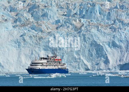 DÄNEMARK. GRÖNLAND. WESTKÜSTE. DAS SEA EXPLORER I, EIN KREUZFAHRTBOOT, VOR DEM GLACIAR EQIP SERMIA IN DER BUCHT VON QUERVAIN. Stockfoto