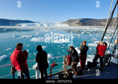 DÄNEMARK. GRÖNLAND. WESTKÜSTE. POLARFLUG. PASSAGIERE EINER KREUZFAHRT, DIE DEN GLACIAR EQIP SERMIA IN DER BUCHT VON QUERVAIN'S SCHIESST. Stockfoto