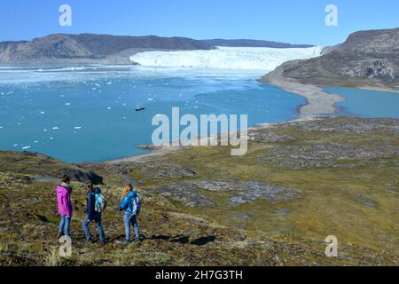 DÄNEMARK. GRÖNLAND. WESTKÜSTE. TOURISTEN, DIE DIE BUCHT VON QUERVAIN MIT DEM GLACIAR EQIP SERMIA IN PORT VICTOR BETRACHTEN, CAMP VON PAUL-EMILE VICTOR, KÜCHENCHEF O Stockfoto