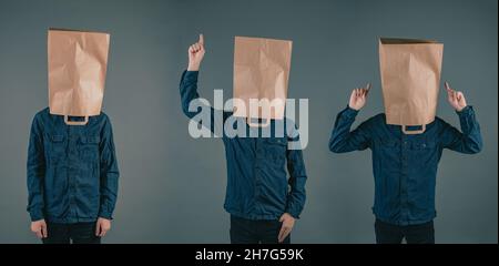 Drei junge Männer mit Papiertüten auf dem Kopf, verschiedenen Handpositionen, Kopierraum, dunklem Hintergrund Stockfoto