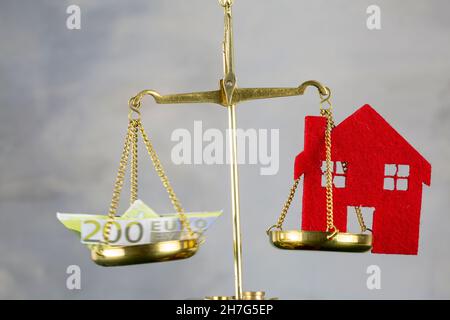Boot aus Euro-Banknote und House Model Balancing on Justice Scale Stockfoto