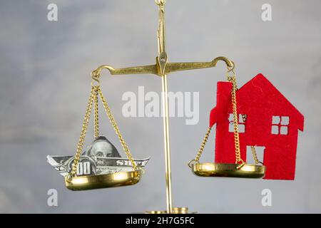Boot von Dollar-Banknote und House Model Balancing on Justice Scale Stockfoto