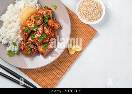 Teriyaki-Huhn mit Reis und Sesam auf hellgrauem Hintergrund. Stockfoto